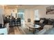 Open-concept living room with hardwood floors and large windows, connected to the kitchen at 1940 Egret Meadows Ave, Kissimmee, FL 34744