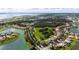 Wide aerial view of a neighborhood with multiple lakes, lush greenery, and well-maintained lawns at 1950 Windward Oaks Ct, Kissimmee, FL 34746