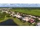 Aerial view of a neighborhood with a lake in the background and lush green spaces at 1950 Windward Oaks Ct, Kissimmee, FL 34746