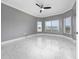Spacious bedroom with marble flooring, a ceiling fan, and plenty of natural light from three windows at 1950 Windward Oaks Ct, Kissimmee, FL 34746
