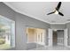 A bedroom featuring a ceiling fan, a window, sliding door access to patio and a door access to hallway at 1950 Windward Oaks Ct, Kissimmee, FL 34746