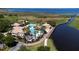 Breathtaking aerial view of the community pool with lake access, surrounded by palm trees and lush landscaping at 1950 Windward Oaks Ct, Kissimmee, FL 34746