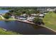Stunning aerial view of community pool with lake access and a covered pavilion in a tropical landscaped community at 1950 Windward Oaks Ct, Kissimmee, FL 34746