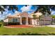 Beautiful home showcasing well-kept landscaping, mature palm trees, tile roofing, and a welcoming front entrance at 1950 Windward Oaks Ct, Kissimmee, FL 34746