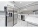 Stainless steel refrigerator and modern white cabinets in a well-lit kitchen with a breakfast bar at 1950 Windward Oaks Ct, Kissimmee, FL 34746
