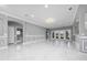 Spacious open living area showcasing gray walls with white trim, tile floors, and a view of the kitchen and outdoor patio at 1950 Windward Oaks Ct, Kissimmee, FL 34746