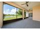 Screened patio offers a tranquil outdoor living space overlooking a lush lawn and serene lake at 1950 Windward Oaks Ct, Kissimmee, FL 34746