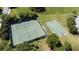 Aerial view of community tennis and basketball courts surrounded by mature landscaping at 1950 Windward Oaks Ct, Kissimmee, FL 34746