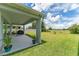 A covered patio and fenced backyard with green grass and trees at 2223 Bluebird Pl, St Cloud, FL 34771