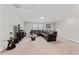Open living room features neutral carpet, an entertainment center, and a brown leather sectional sofa at 2223 Bluebird Pl, St Cloud, FL 34771