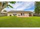 Spacious backyard featuring a well-maintained lawn, patio area for outdoor seating, and mature trees at 2569 Tandori Cir, Orlando, FL 32837