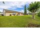 Spacious backyard featuring a well-manicured lawn, patio with outdoor seating, and mature landscaping at 2569 Tandori Cir, Orlando, FL 32837