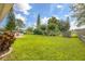 Expansive backyard featuring well-maintained lawn, mature trees, and outdoor seating area at 2569 Tandori Cir, Orlando, FL 32837