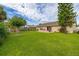 Wide backyard showcasing a lush green lawn, patio with seating, and mature landscaping at 2569 Tandori Cir, Orlando, FL 32837