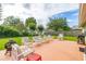 Large backyard with lush green lawn, patio seating area, and mature trees at 2569 Tandori Cir, Orlando, FL 32837