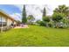 Large backyard offering lush green grass, an outdoor patio with seating, and mature trees at 2569 Tandori Cir, Orlando, FL 32837
