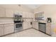Bright kitchen featuring stainless steel appliances, light wood cabinets, and tiled flooring at 2569 Tandori Cir, Orlando, FL 32837