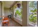 Cozy screened-in porch with seating, hanging plants, and a view of the tropical landscaping at 2569 Tandori Cir, Orlando, FL 32837