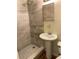 Bathroom with a shower, neutral tile, and a pedestal sink at 2619 Milton Ave, Kissimmee, FL 34741