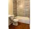 Bathroom with a tub, neutral tile, and a toilet at 2619 Milton Ave, Kissimmee, FL 34741