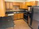 Functional kitchen with stainless steel appliances, wood cabinets, and dark countertops at 2619 Milton Ave, Kissimmee, FL 34741