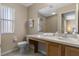 Bathroom features a large mirror, single sink, window, toilet, and towels at 2708 Camaro Dr, Kissimmee, FL 34746