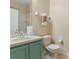 Cozy bathroom featuring a green vanity, commode, shower and ample natural light at 2708 Camaro Dr, Kissimmee, FL 34746