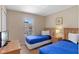 Bright bedroom featuring two twin beds with blue comforters and a window offering a pleasant view at 2708 Camaro Dr, Kissimmee, FL 34746