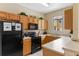 Functional kitchen with wood cabinets, black appliances, and a window offering natural light at 2708 Camaro Dr, Kissimmee, FL 34746
