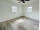 Sunlit bedroom features tiled floors, fresh neutral paint, ceiling fan and two bright windows at 329 N Hart Blvd, Orlando, FL 32835