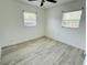 Well-lit bedroom with sleek tiled floors, neutral walls, ceiling fan, and bright windows at 329 N Hart Blvd, Orlando, FL 32835