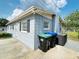 Back exterior view of the home, complete with trash receptacles and an A/C unit at 329 N Hart Blvd, Orlando, FL 32835