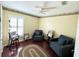 Inviting bedroom area with light yellow wall paint, ceiling fan, window with shutters, plus 2 dark grey chairs at 3407 Santa Monica Dr, Orlando, FL 32822