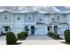 Charming light blue two-story townhome featuring a one-car garage and manicured landscaping at 4634 Tribute Trl, Kissimmee, FL 34746