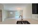 Stylish kitchen with stainless steel sink, white countertops, and an open view to the living room at 4634 Tribute Trl, Kissimmee, FL 34746