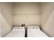 Well-organized laundry area equipped with washer, dryer, and shelving for streamlined storage and convenience at 4634 Tribute Trl, Kissimmee, FL 34746