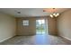 Bright living room with tile floors, sliding glass doors to the backyard, and a modern chandelier at 4634 Tribute Trl, Kissimmee, FL 34746