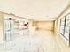Open-concept living room and kitchen area with bright white cabinets and sleek marble-patterned tile flooring at 4917 Easton St, Lake Wales, FL 33859