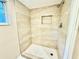 Modern walk-in shower with neutral tile, niche, and hexagon tile flooring at 4917 Easton St, Lake Wales, FL 33859