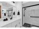 Modern bathroom with white vanity, black hardware, and sleek glass shower with black and white tile at 511 Mobley Dr, Deltona, FL 32725