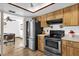 Kitchen with stainless steel appliances, wood cabinets, and a view into the dining area at 511 Mobley Dr, Deltona, FL 32725