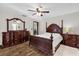 Spacious main bedroom with wood-look floors, ceiling fan, and beautiful dark wood furniture at 511 Mobley Dr, Deltona, FL 32725