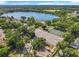 Scenic aerial view of a lakefront community, highlighting a lake, tennis courts, playground and tree-lined streets on a sunny day at 5312 Kingswood Dr, Orlando, FL 32810
