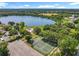 Aerial view showcases a stunning lake view, tennis courts, and an expansive parking area, offering a blend of recreation and convenience at 5312 Kingswood Dr, Orlando, FL 32810
