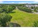 Expansive grassy lot surrounded by mature trees, providing privacy and a serene environment near a lake and residential areas at 5312 Kingswood Dr, Orlando, FL 32810