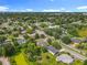Aerial view of a neighborhood street surrounded by trees, homes, and green landscapes under a blue sky at 5312 Kingswood Dr, Orlando, FL 32810