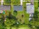 Aerial view of a home with a large backyard, mature trees, and a small shed near a canal at 5312 Kingswood Dr, Orlando, FL 32810