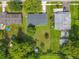 Aerial view of a home with a large backyard, mature trees, and a small shed near a canal at 5312 Kingswood Dr, Orlando, FL 32810