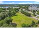 Expansive grassy lot surrounded by mature trees, providing privacy and a serene environment near a lake and residential areas at 5312 Kingswood Dr, Orlando, FL 32810
