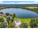 An aerial view of a lakeside community park featuring a pool, tennis courts, and mature trees at 5312 Kingswood Dr, Orlando, FL 32810